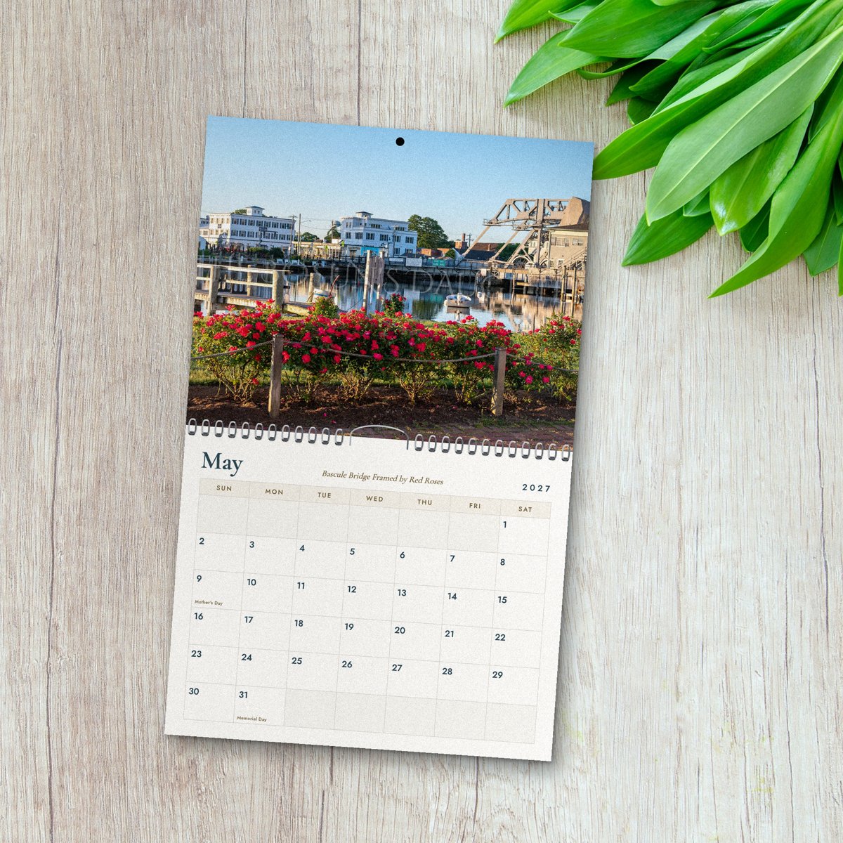 May page of the Mystic River 2027 calendar: the Mystic bascule bridge and waterfront framed by red roses