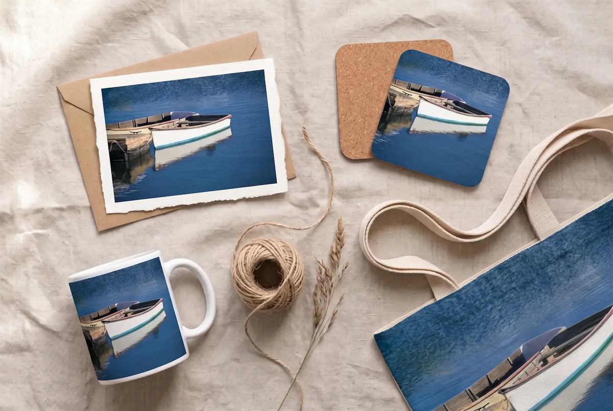 Flat greeting cards printed with a photograph of a moored boat, fanned out beside an envelope
