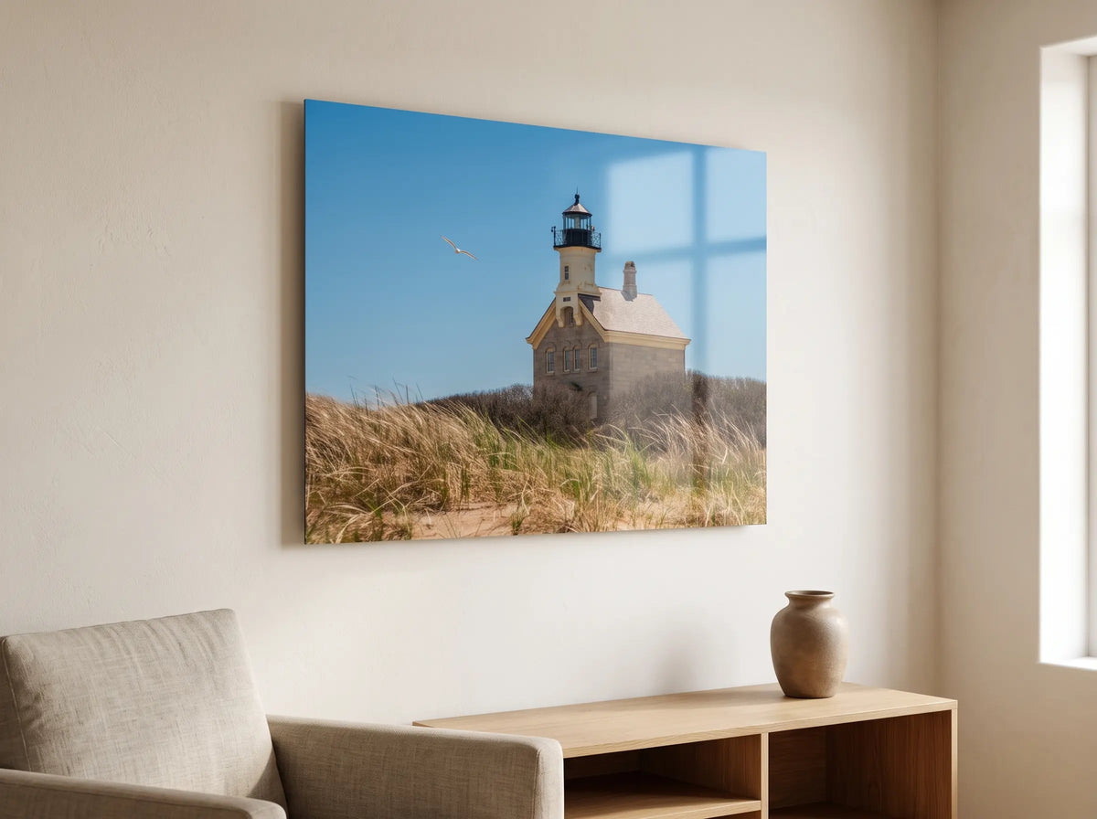 Metal print of a stone lighthouse in the dunes on a living room wall